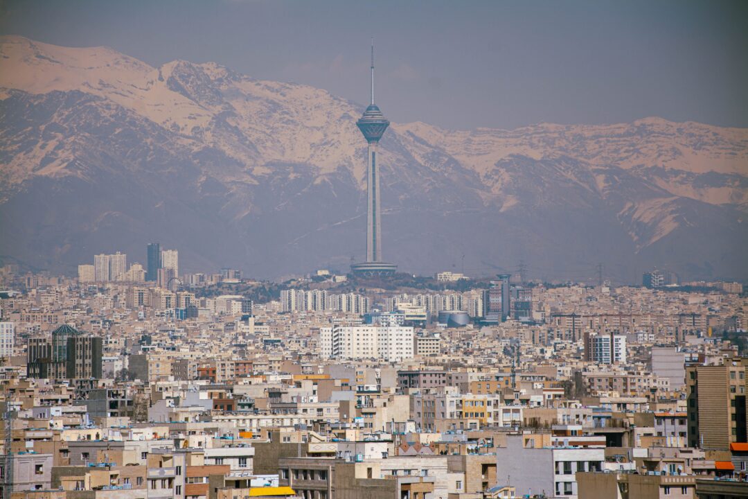A view of Tehran with the mountains silhouetted in the background.